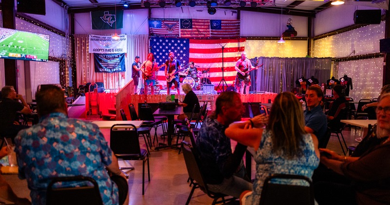 Interior, stage with band, benches and tables, guest seating