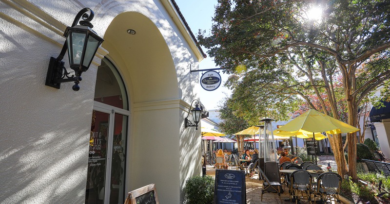 Exterior, entrance and  patio space under a tree, with seated guests