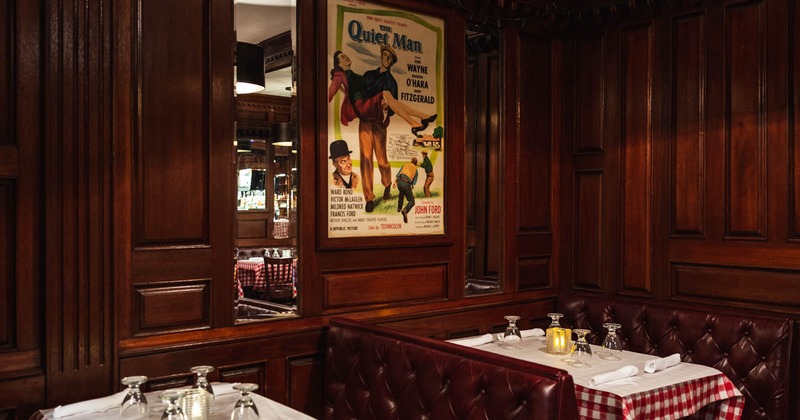 Booths seating space, with vintage poster on the wall