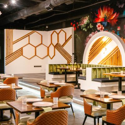 Interior with both booth and table seating and a honeycomb-patterned wall panels.