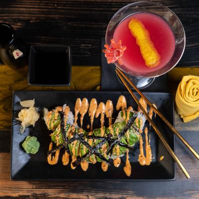 Nichols Hills Mr. Limpet roll and a pink cocktail served in Martini glass, top view.