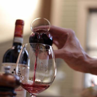 Customer pouring red wine.