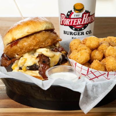 Bacon cheeseburger with onion ring, BBQ sauce, mac and cheese, and tater tots.