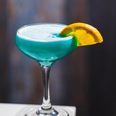 Blue Lagoon cocktail, garnished with a lemon wedge.