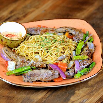 Spaghetti and Steak with grilled vegetables and dressing on the side.