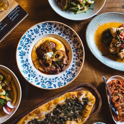 Assortment of food plates spread on a table, flat lay.