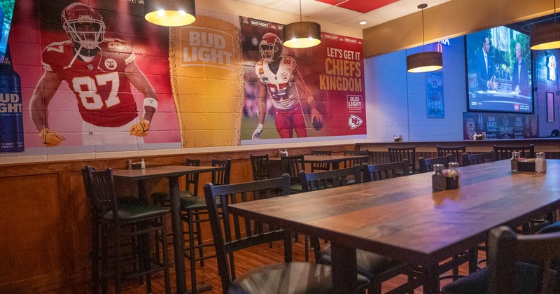 Interior, high seating tables with bar stools, NFL and Bud Light commercial mural