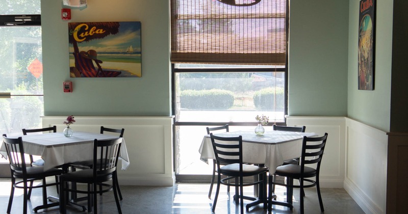 Interior, dining area, seating by the window, tables for four, ready for guests