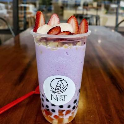 Purple smoothie topped with strawberries and banana.