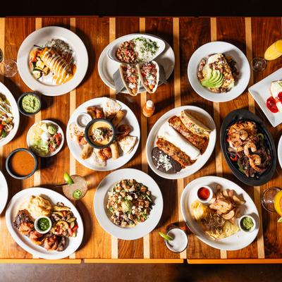 Miscellany of dishes and drinks spread on a table, top view.