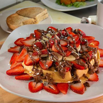 Waffles topped with strawberries, bananas, and Nutella.
