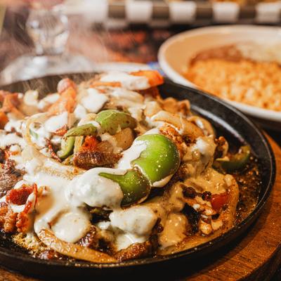 Sizzling chicken fajitas with peppers, onions, and cheese.