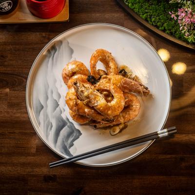 Garlic sea salt prawns served on a plate with chopsticks.