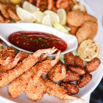 Fried Shrimp Platter featuring fried seafood bites, cocktail sauce and lemon wedges.