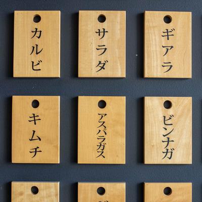 Wooden tags with Japanese characters on a dark background.