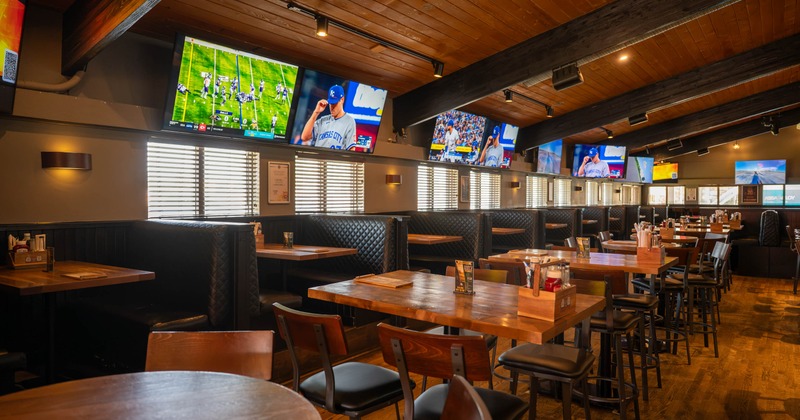 Interior, wooden tables, leather booths, exposed ceiling beams, multiple televisions