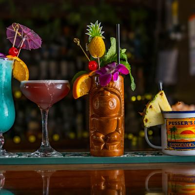 Assorted cocktails lined up on a bar counter.