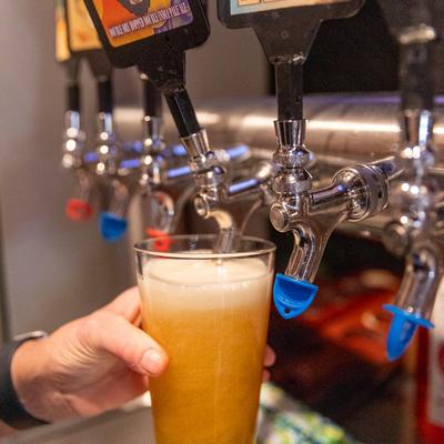 A hand pouring beer from the dispensary.