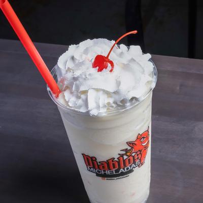 Pina Colada topped with whipped cream and a cherry.