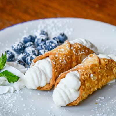 Mini Cannolis with whipped cream,  blueberries and powdered sugar