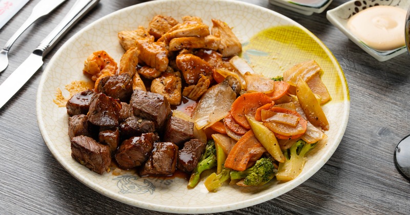 Hibachi steak and chicken served with vegetables