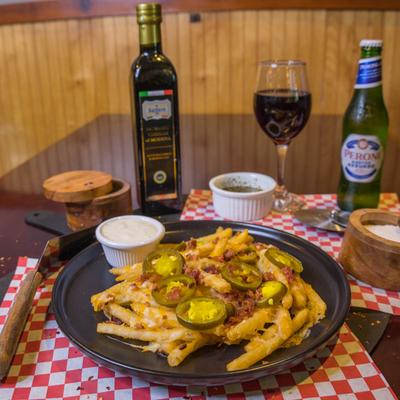 Loaded fries topped with bacon, jalapenos, and melted cheese, served with drinks and dipping sauces.