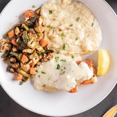 Grilled salmon, with lemon butter sauce, grilled vegetables, and mashed potatoes.