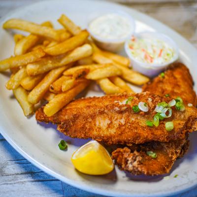 Fried fish filets with fries, coleslaw, and dipping sauce.