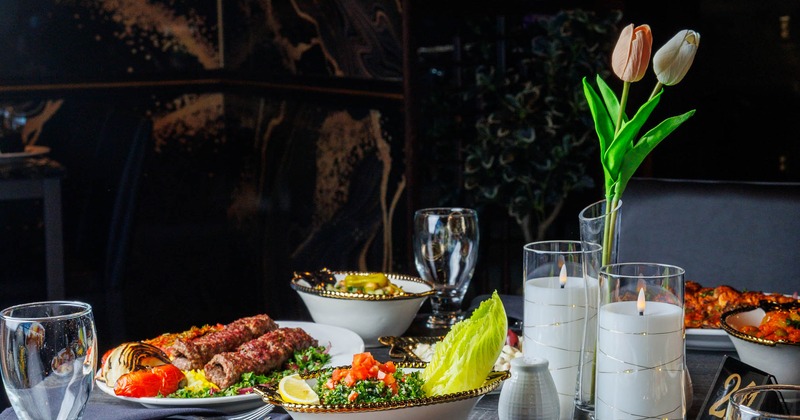 Table set with different dishes, glasses and candles