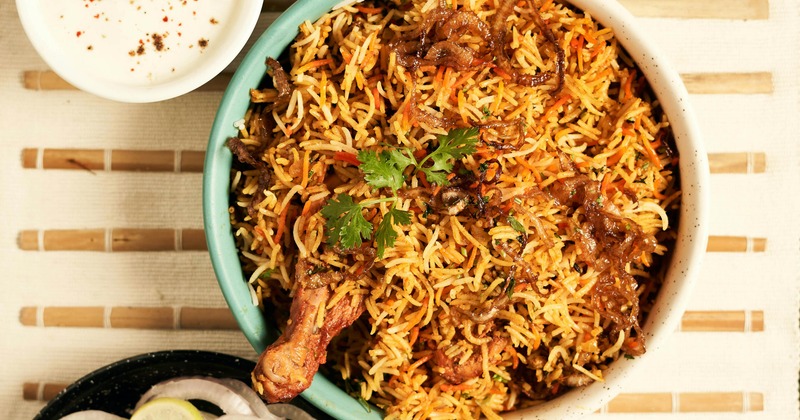 Chicken biryani topped with fried onions and cilantro