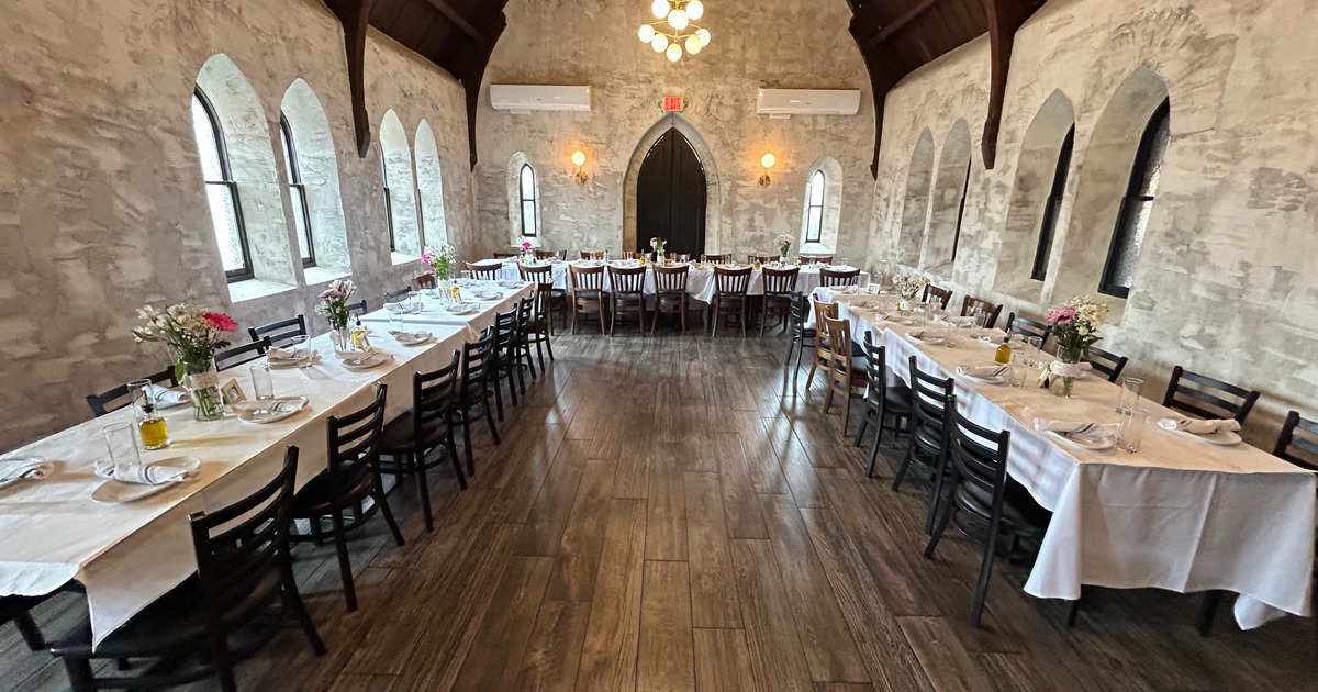 A spacious room featuring tables and chairs, set up for a celebration