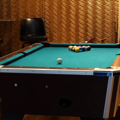 Interior, closeup of a pool table with lined up balls.