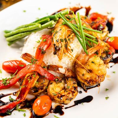 Grilled shrimp with rice, asparagus, tomatoes, red peppers, and balsamic glaze.
