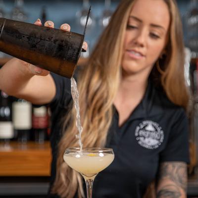 An employee pouring a cocktail