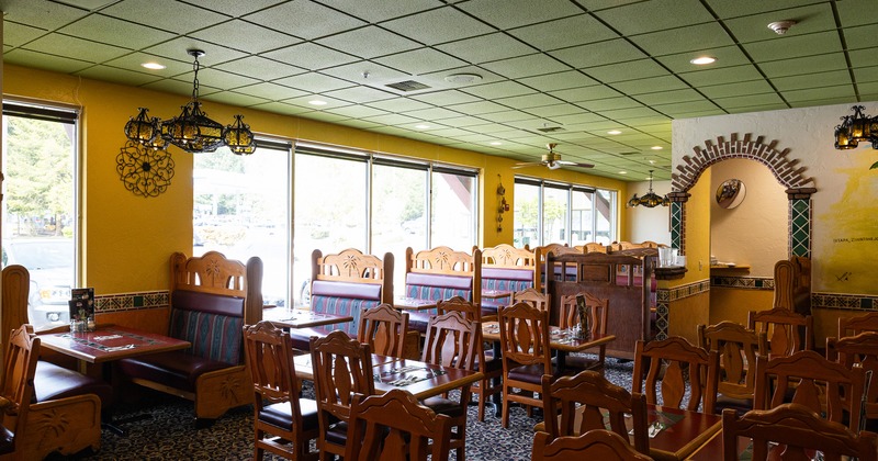Interior of a cozy Mexican-style restaurant, dining area with wooden tables and chairs