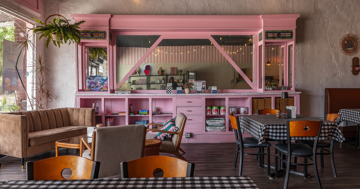 A bright and cozy interior dining area and pastel pink service counter