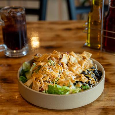TexMex Bowl with rice, chicken, sweet corn, guacamole, cheese, sour cream and tortilla chips.