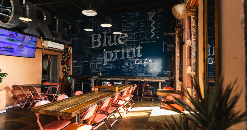 Seating area with a long wooden table and folding chairs, ideal for casual dining or gatherings