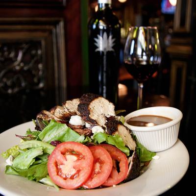 A chicken salad served with red wine.
