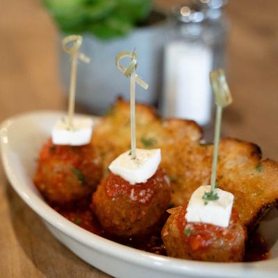 Three house meatballs with sauce Pomodoro, mozzarella & basil, served with bread.