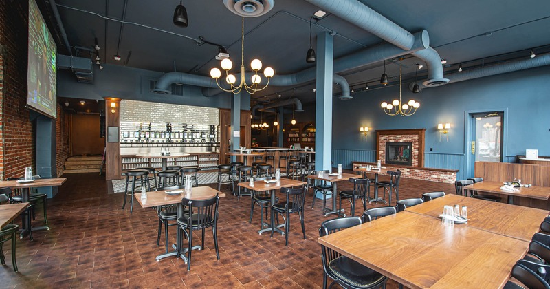 Interior of a modern restaurant with wooden tables and black chairs