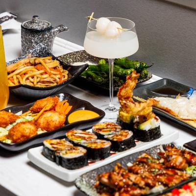 Various dishes served on the table alongside a cocktail in coupe glass.
