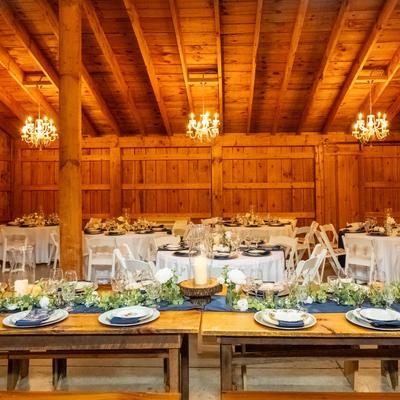 Rustic barn interior with chandeliers, ready for a wedding reception.