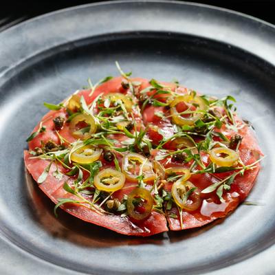 Tuna Pizza with capers, serrano peppers, and red onions.