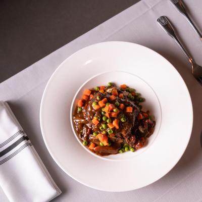 Beef stew topped with diced vegetables.