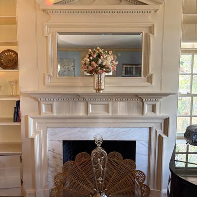 Ornate white fireplace with marble surround.