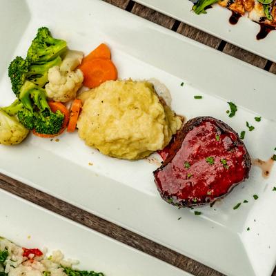 Filet Mignon served with mashed potatoes, broccoli, cauliflower and carrot, top view