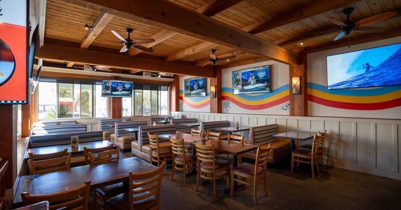 Bright, wooden-furnished restaurant interior with tables and booths