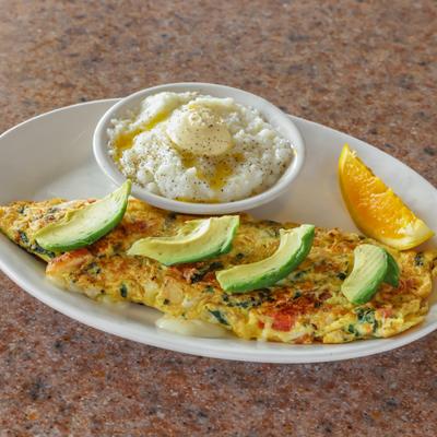 Omelet served with avocado and grits..
