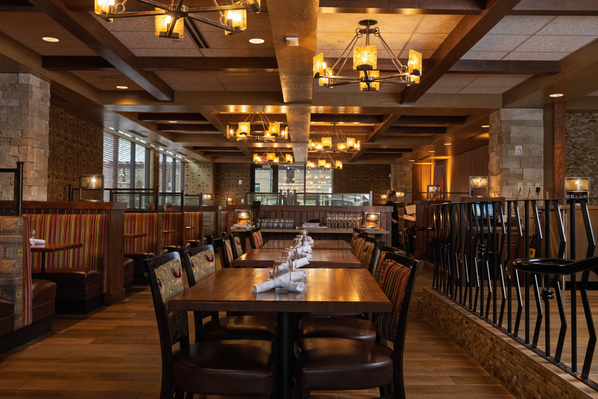Interior with wooden tables, chairs, booths, and warm lighting